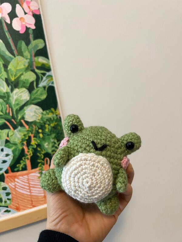 Adorable green amigurumi frog stuffed toy with cheerful smile