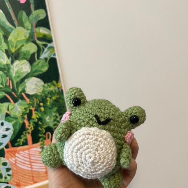 Adorable green amigurumi frog stuffed toy with cheerful smile